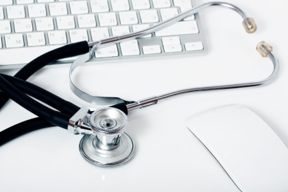 an image of medical tool on a table at a computer as a medical professional reviews his tax account